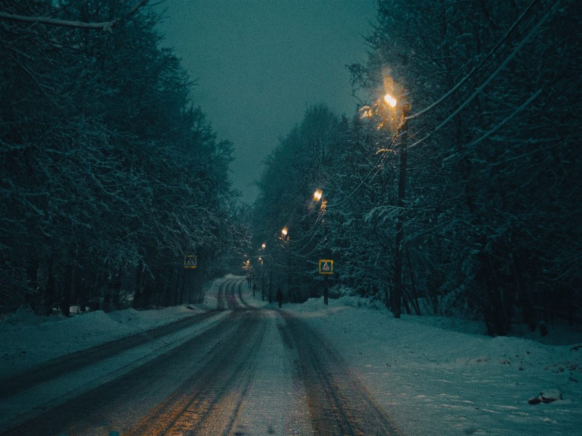 Cold winter road lit by warm lanterns
