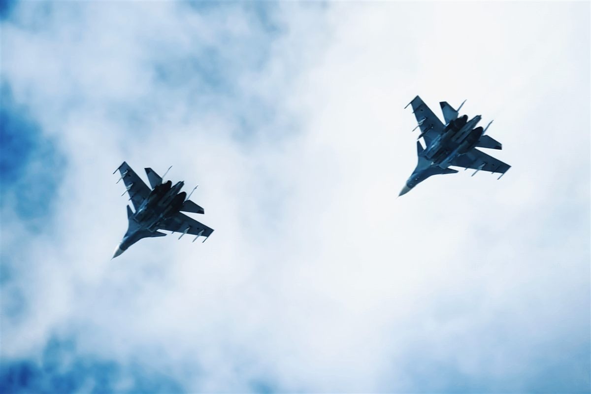 Two fighter jets in tandem on a blue sky